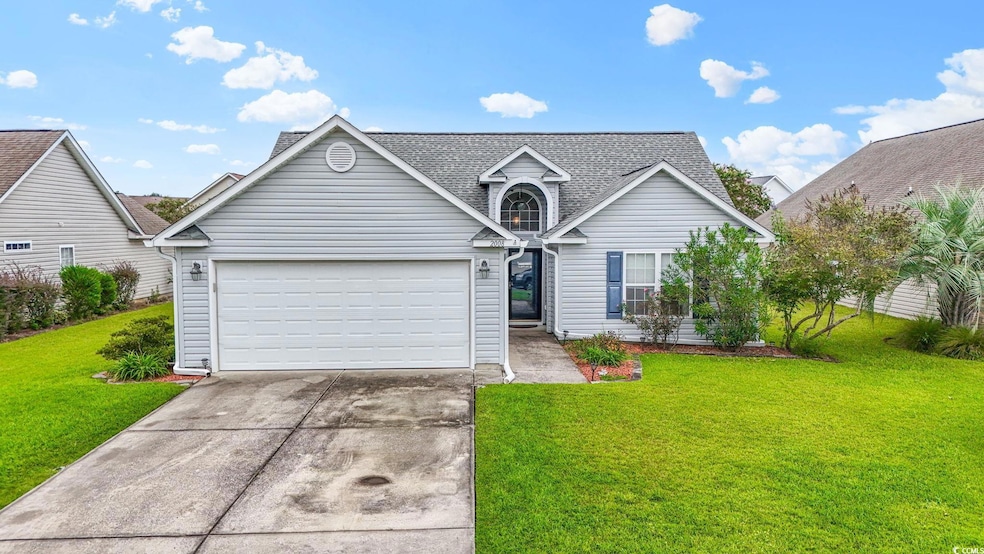 Traditional-style house featuring a front yard, concrete driveway, a garage, and roof with shingles