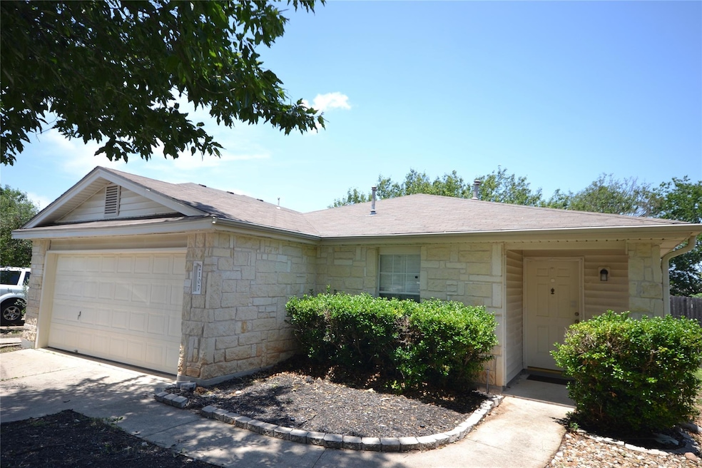 Ranch-style house with stone siding, an attached 