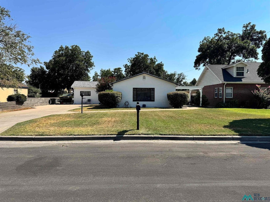View of front facade featuring a front lawn and concrete driveway