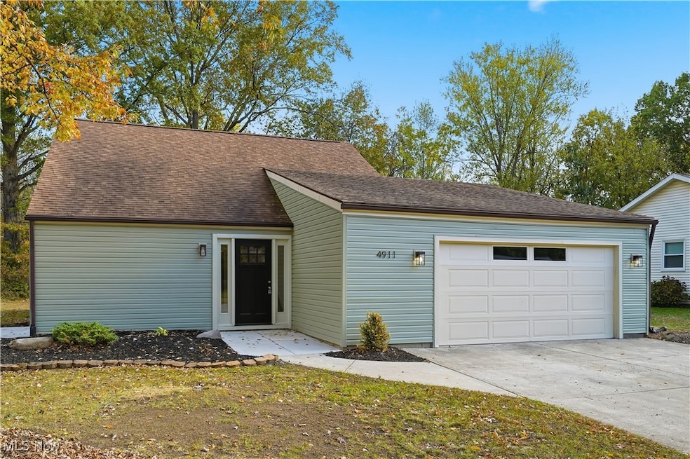 View of front of property featuring driveway, a garage, a shingled roof, and a front yard