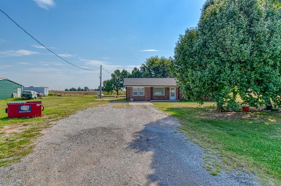 View of front of property featuring driveway, a front lawn, and brick siding