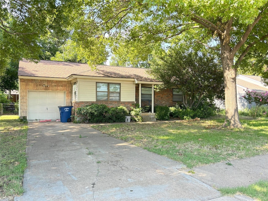 Ranch-style house featuring a garage and a front y