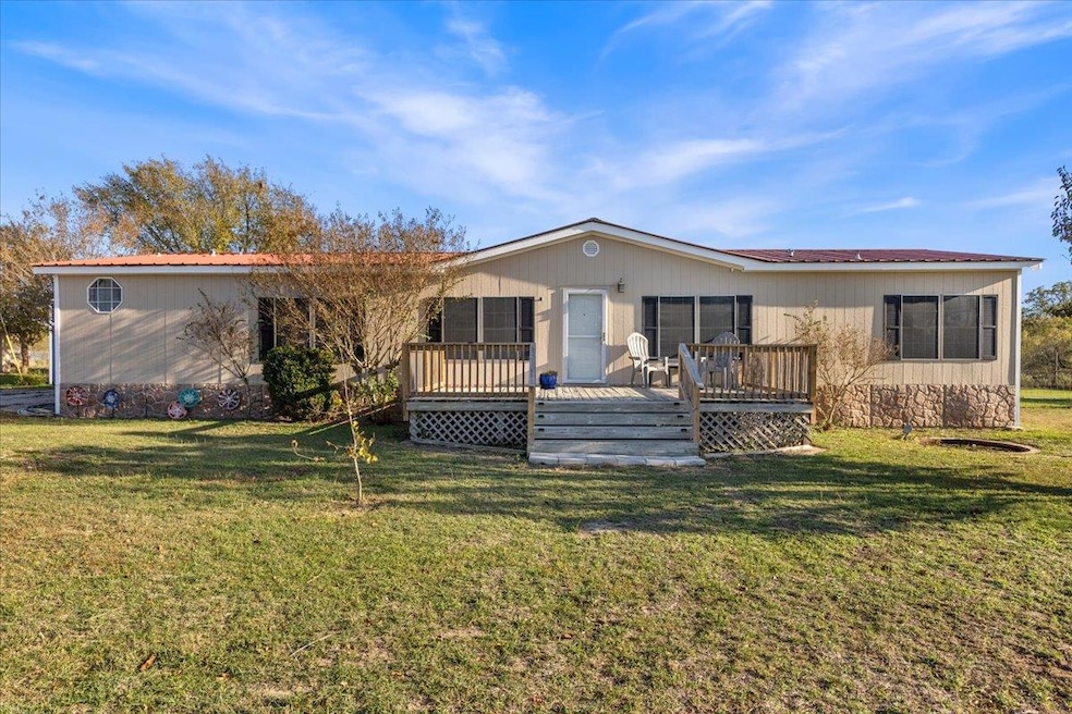 Rear view of house with a yard and a wooden deck
