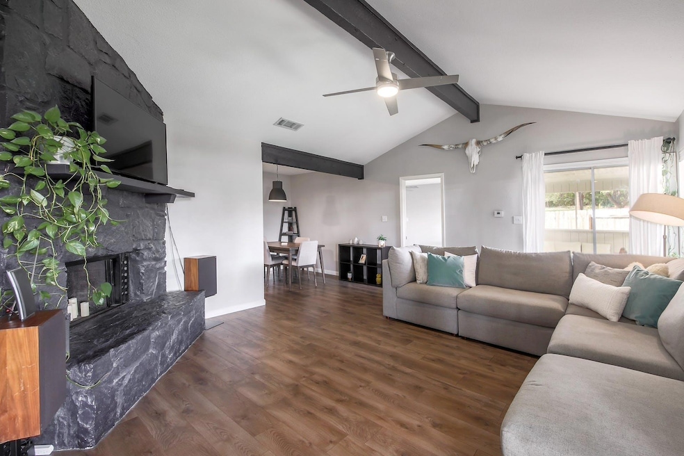 Living area featuring ceiling fan, vaulted ceilin