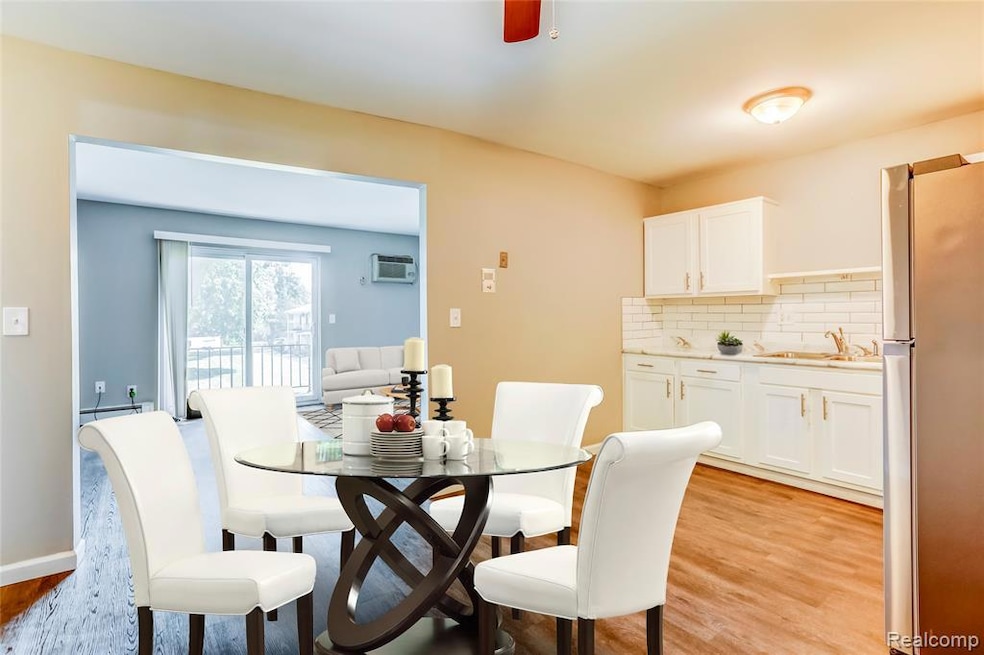 Dining space with light wood-style flooring, ceiling fan, and a baseboard heating unit