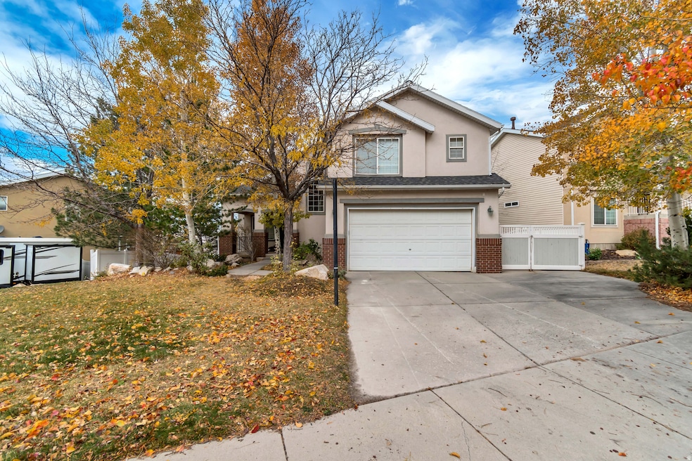 Traditional-style house featuring stucco siding, driveway, a garage, and brick siding