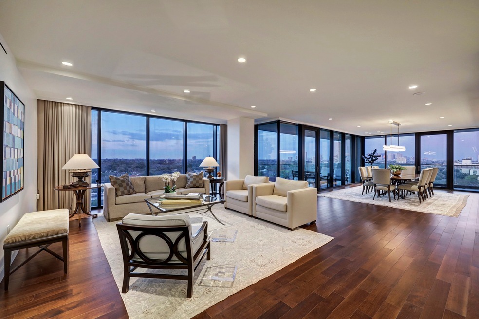 The spacious Formal Living Room [26x16] features beautiful, richly stained engineered hardwood floors, recessed non-glare lighting, floor-to-ceiling windows providing stunning River Oaks views, hidden electric shades and flows seamlessly into the Formal Dining Room and Kitchen. Doorway closer to the Dining Room provides access to expansive wrapround patio.