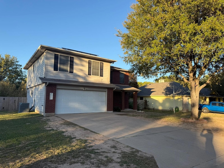 View of front of property featuring driveway, a garage, brick siding, and a front yard