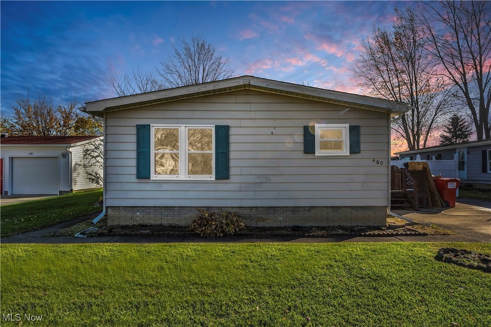 Property exterior at dusk with a garage and a lawn