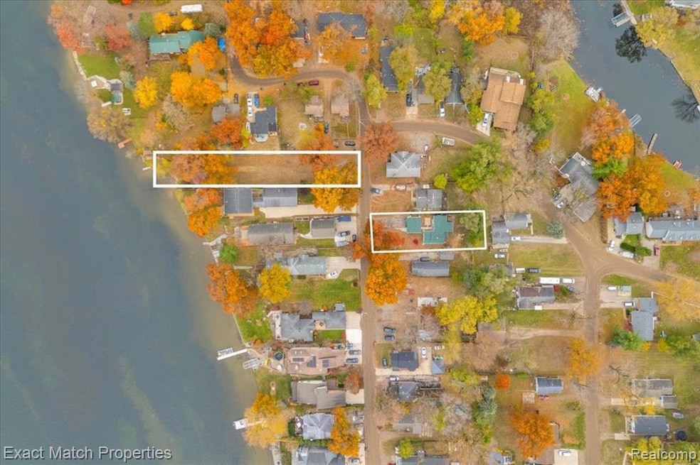 Aerial perspective of suburban area featuring a large body of water