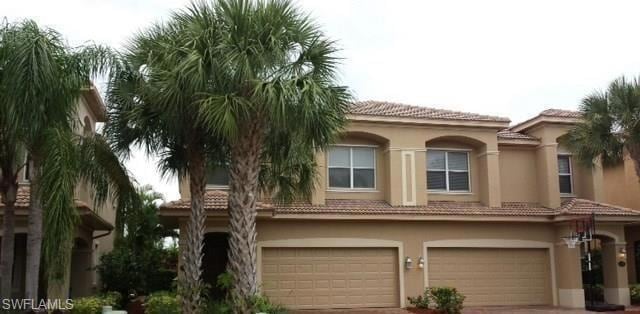 View of front of house with stucco siding, a tiled