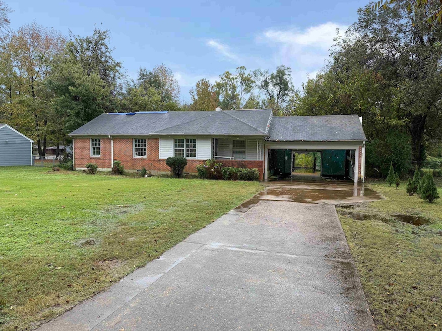 Ranch-style home featuring a front lawn and a carp