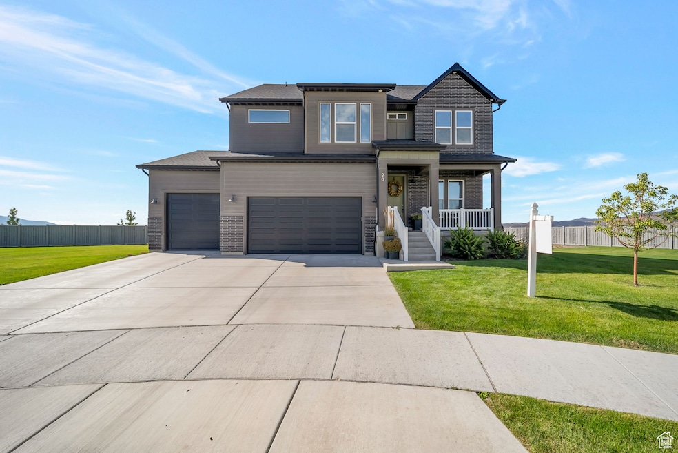View of front of property featuring brick siding, a porch, driveway, and an attached garage