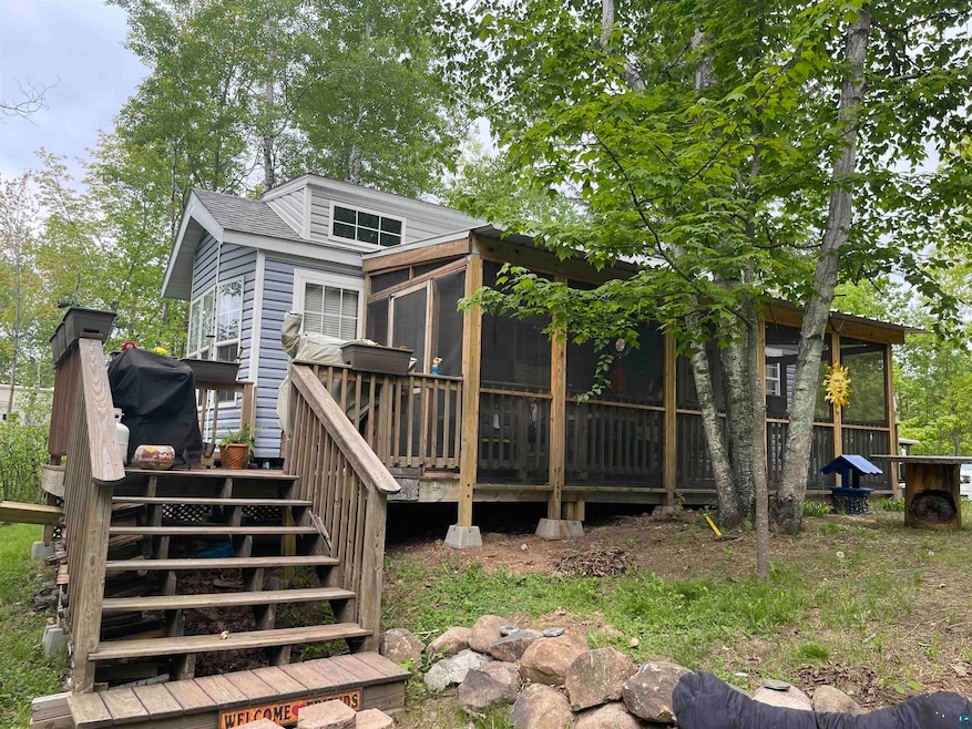 Rear view of property with a sunroom, stairs, and a deck