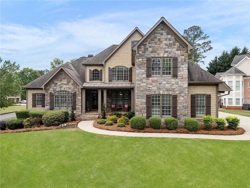 French country home with stone siding, covered por