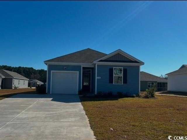 View of front facade with a garage and a front law