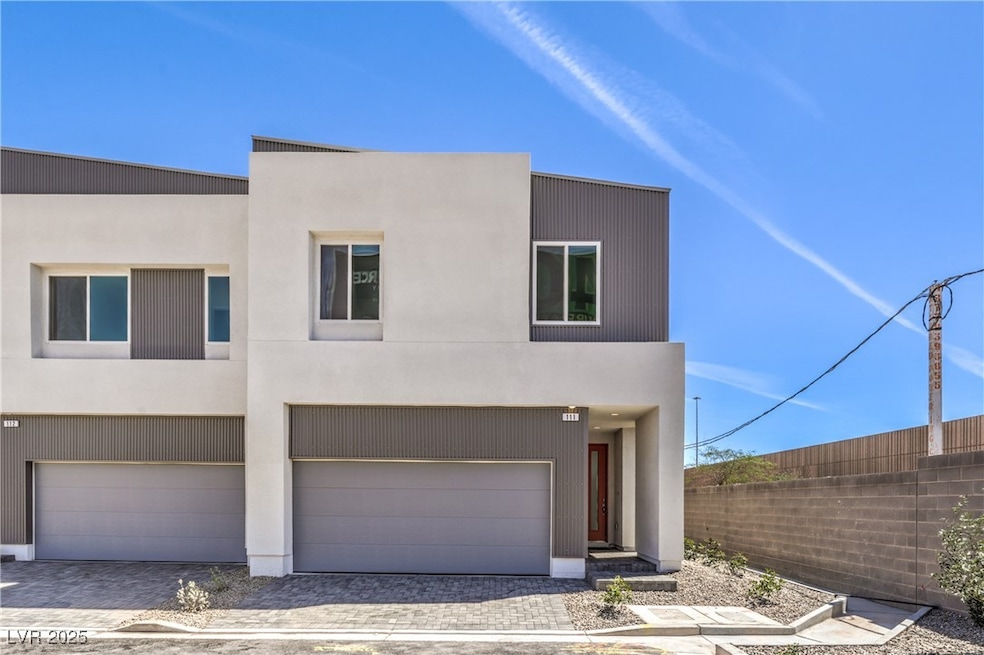 Contemporary house featuring a garage, driveway, and stucco siding