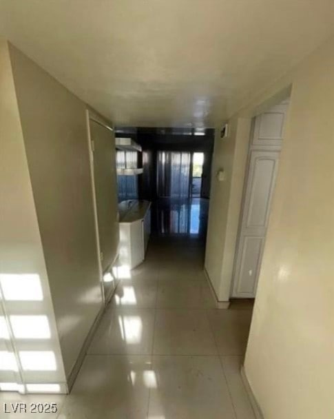 Corridor with light tile patterned floors and base