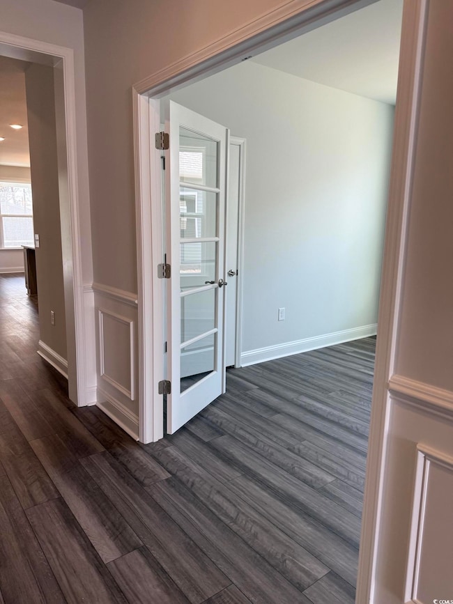 Corridor with dark hardwood / wood-style floors