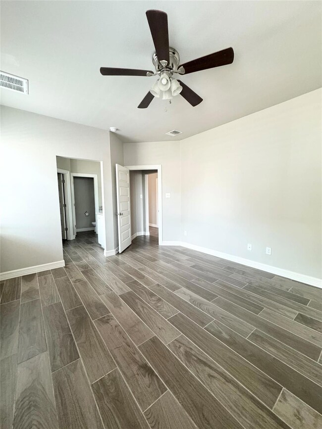 Unfurnished bedroom with wood finish floors and a ceiling fan