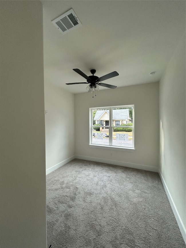 Unfurnished room with light colored carpet and ceiling fan
