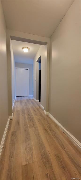 Hallway featuring wood-type flooring and baseboards