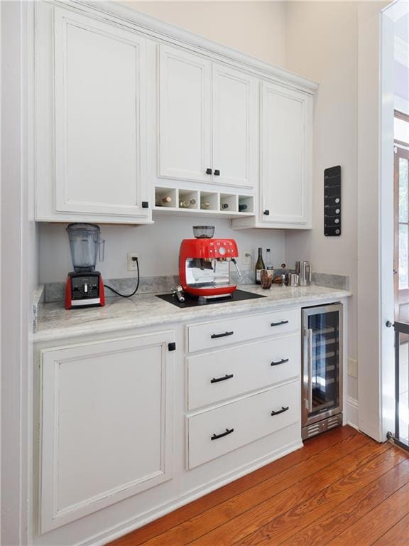 Indoor dry bar featuring wine cooler and wood finished floors