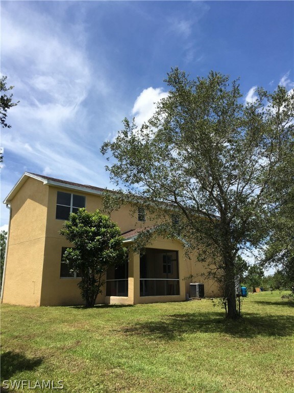 Back side of house.  2 mature trees. Room for pool.