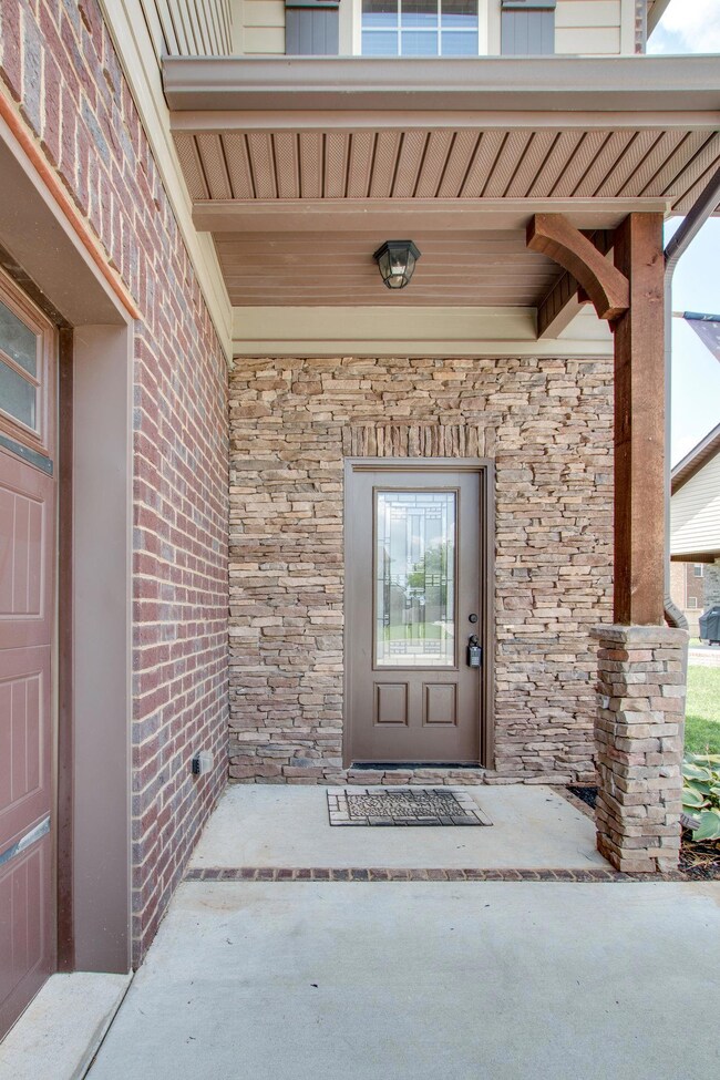 Covered front porch with stacked stone and brick.