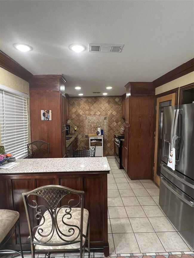 Kitchen featuring refrigerator, light tile pattern