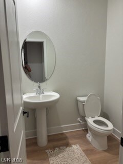 Bathroom with wood finished floors, toilet, and ba