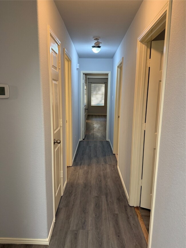 Hall featuring baseboards and dark wood finished floors