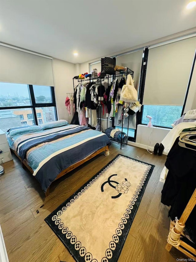 Bedroom with multiple windows and wood finished floors