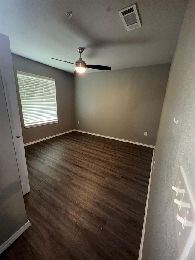Spare room with dark wood-type flooring, visible v