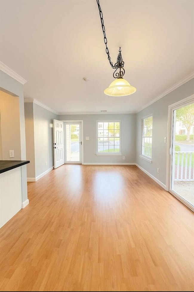 Unfurnished living room with crown molding and light wood finished floors