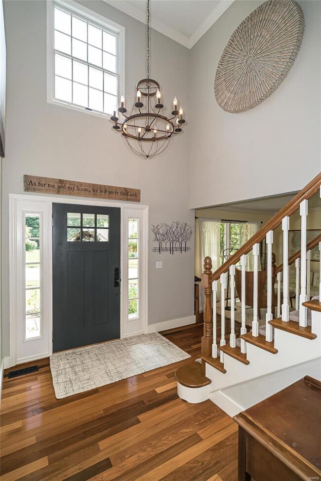The beautiful Entry Foyer is lit by a beautiful ch