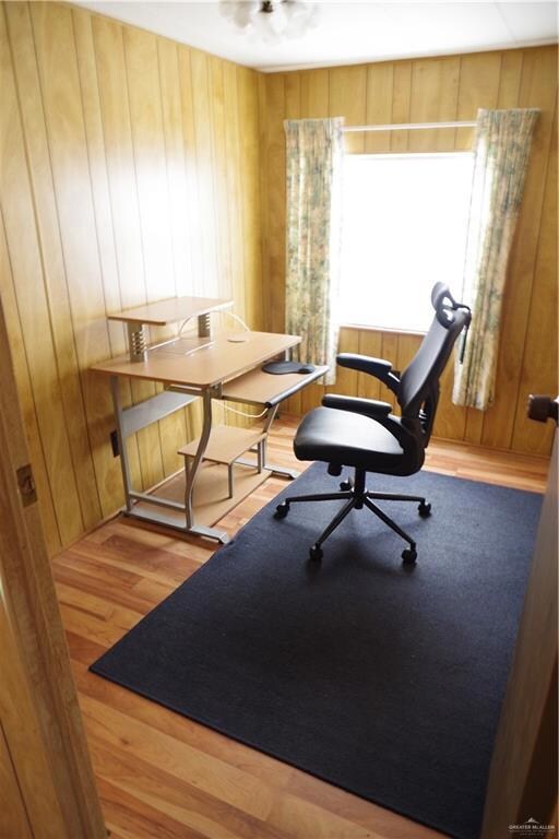 Office area featuring wooden walls and light hardwood / wood-style flooring