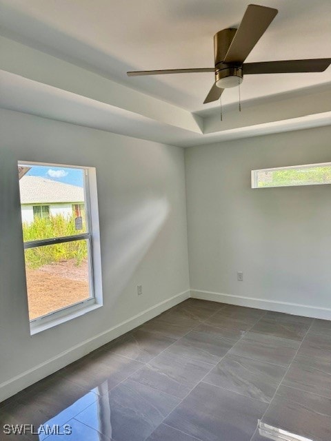 Spare room featuring a ceiling fan, baseboards, an