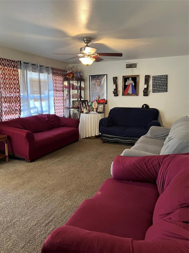 Living room with ceiling fan and carpet flooring