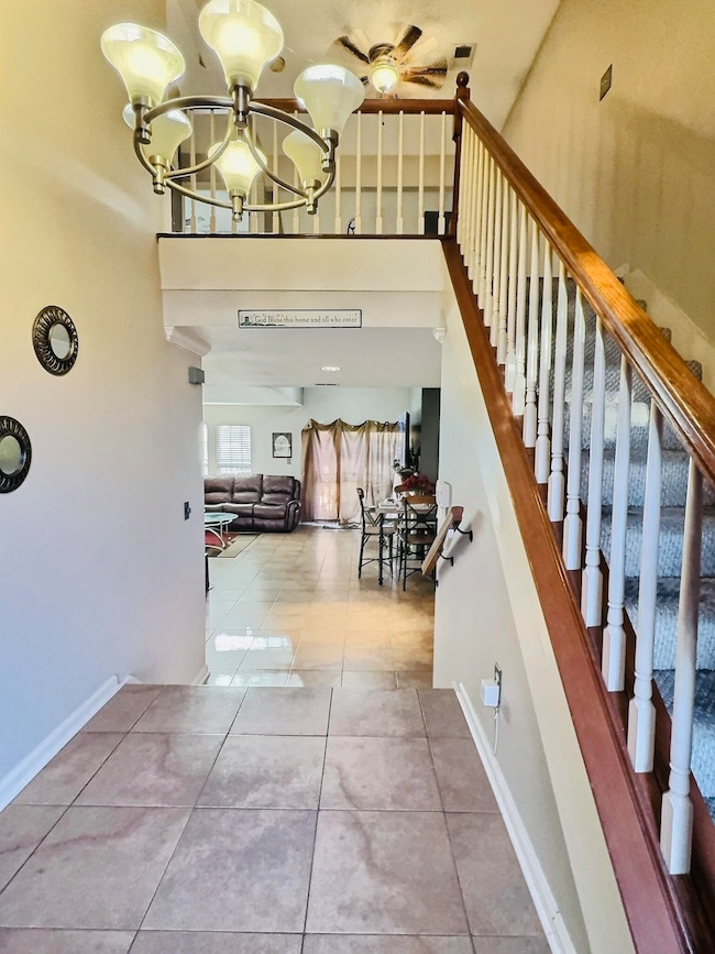 Stairs with baseboards, a notable chandelier, and 