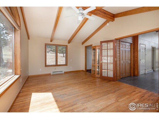 Primary bedroom with walk-in closet, hardwood floors and French doors