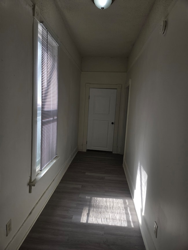 Hallway featuring wood finished floors and baseboards