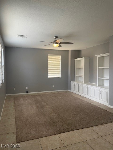 Spare room featuring a ceiling fan, light tile pat