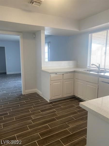 Kitchen featuring white dishwasher, wood finish fl