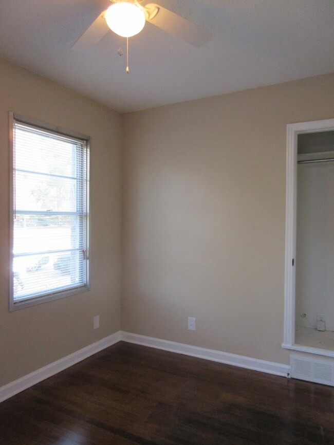 Empty room with a ceiling fan, dark wood finished 