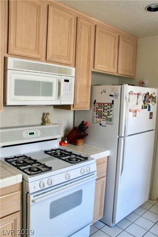 White appliances and tile brighten this kitchen