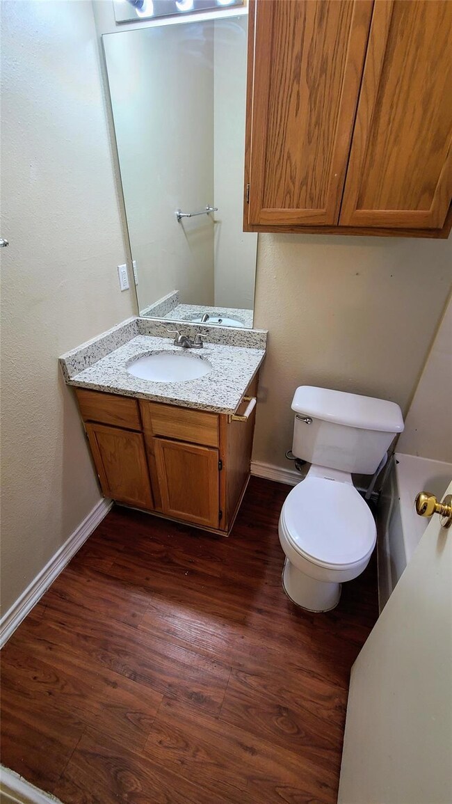 Bathroom with wood finished floors, vanity, baseb