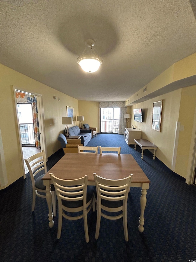 Dining space with a textured ceiling and carpet floors