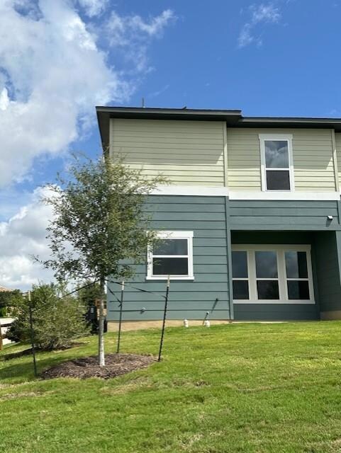 View of property exterior featuring a lawn