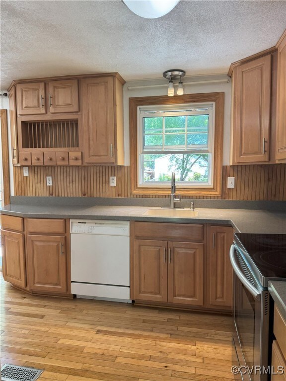 Kitchen with white dishwasher, a sink, a textured